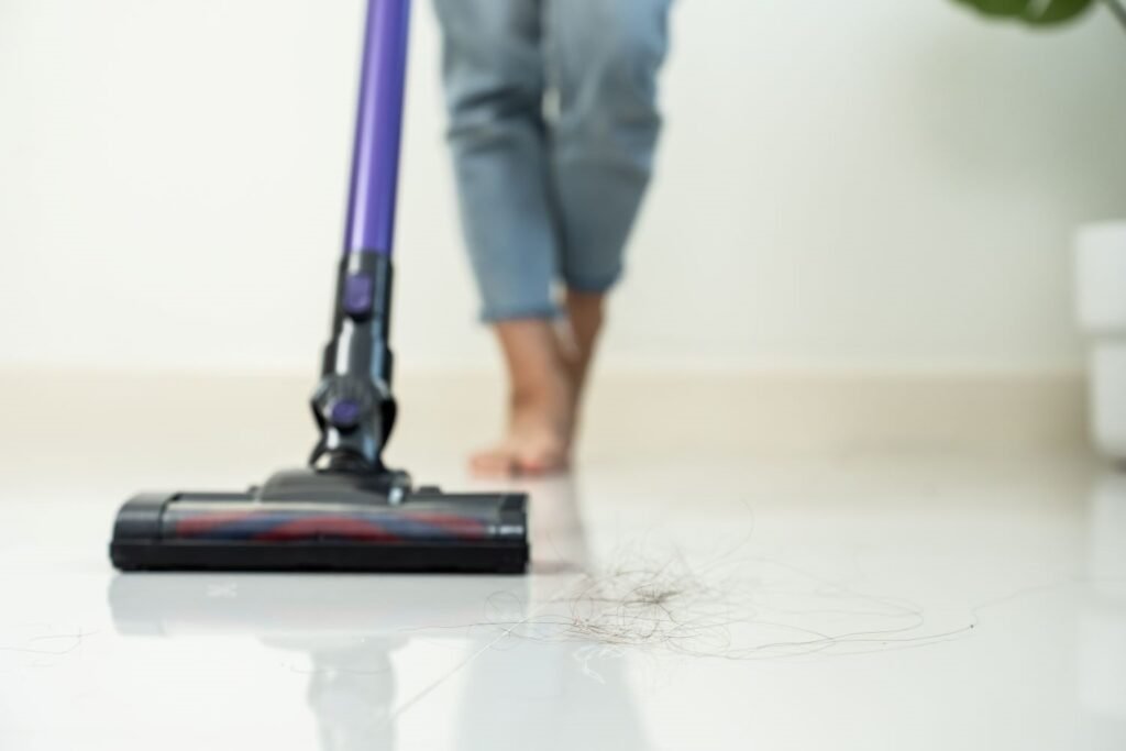 Person saugt einen Boden in der richtigen Reihenfolge der Hausreinigung