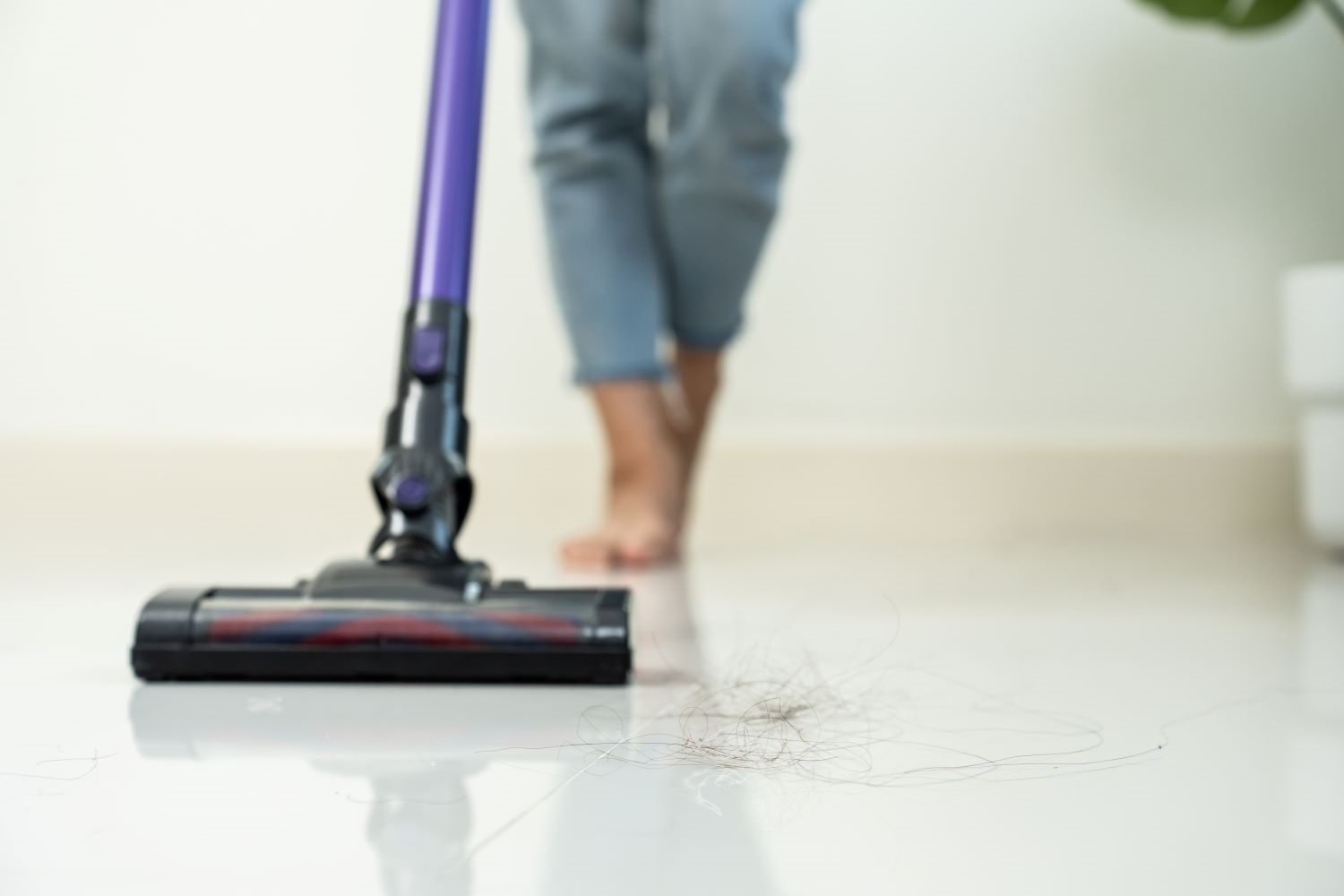 Person vacuuming a floor while following the correct house cleaning order