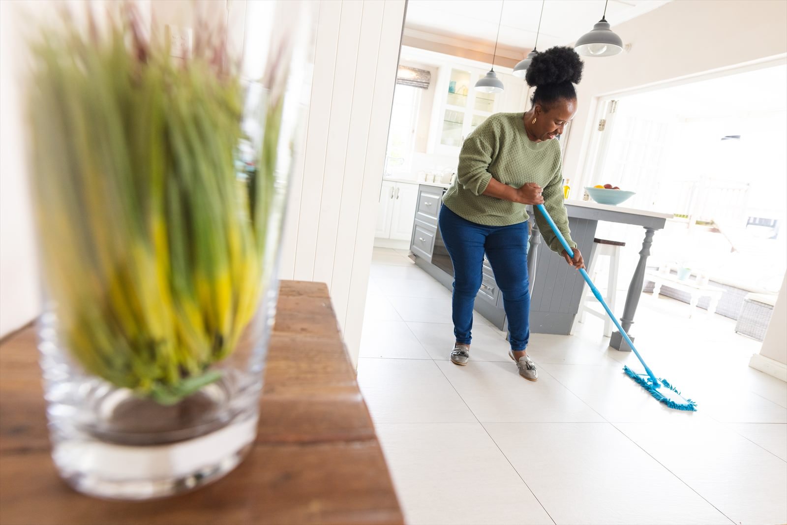 Wischen des Küchenbodens bei der wöchentlichen Hausreinigung